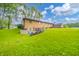 View of brick home featuring a lush green lawn and a small shed at 2900 Helms Rd, Anderson, IN 46016