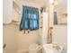 Cozy bathroom featuring a toilet, sink, small storage cabinet, blue window covering, and a mirror at 2900 Helms Rd, Anderson, IN 46016