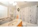 Bathroom with single sink vanity, large mirror, neutral colored walls, and a tub with shower curtain at 2900 Helms Rd, Anderson, IN 46016