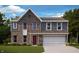 Two-story brick home featuring blue siding, a two-car garage, red front door, and a well-manicured lawn at 331 Oxford Ln, Lebanon, IN 46052
