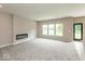 Spacious living room featuring plush carpet, an electric fireplace, and three windows at 331 Oxford Ln, Lebanon, IN 46052