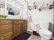 Traditional bathroom featuring a wood vanity, neutral walls, white toilet, and decorative shelving at 3400 Debra Dr, Anderson, IN 46012