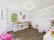 Bright bedroom with wood floors, changing table, decorative accents and a large window at 3400 Debra Dr, Anderson, IN 46012