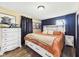 Comfortable main bedroom featuring a large bed, wood-look floors, and dark accent wall at 3400 Debra Dr, Anderson, IN 46012