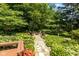 Lush backyard garden leading to a stone firepit with surrounding chairs, perfect for outdoor gatherings at 3479 Sugar Loaf Ct, Carmel, IN 46033