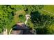 Aerial view of backyard with mature trees, firepit area with seating, and landscaped patio at 3479 Sugar Loaf Ct, Carmel, IN 46033