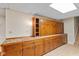 Basement storage with a long counter, cabinets, and tiled backsplash, complemented by overhead lighting at 3479 Sugar Loaf Ct, Carmel, IN 46033