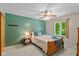 Charming bedroom with green accent wall, comfortable bed, and natural light at 3479 Sugar Loaf Ct, Carmel, IN 46033