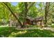 Charming home featuring a brick and wood facade, a red door, and mature trees in a landscaped front yard at 3479 Sugar Loaf Ct, Carmel, IN 46033