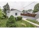 Side view of the home, revealing a spacious paved driveway, mature trees, and tidy landscaping around the perimeter at 454 E Broadway St, Greenwood, IN 46143