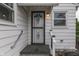 Close-up of the front door, featuring a secure iron gate and a well-lit entrance with steps and a handrail at 454 E Broadway St, Greenwood, IN 46143