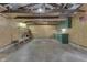 Spacious garage interior with plywood walls, cabinets, overhead lighting, and a clean concrete floor at 454 E Broadway St, Greenwood, IN 46143