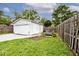 A backyard featuring a detached garage and firepit with chairs at 4910 W Caven St, Indianapolis, IN 46241