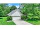 An aerial view of a beautiful home featuring a two-car garage, long driveway, and a yard full of mature trees at 50 Charing Cross Rd, Indianapolis, IN 46217