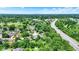 An aerial shot of a neighborhood with lush greenery, a nearby highway, and a distant city skyline on the horizon at 50 Charing Cross Rd, Indianapolis, IN 46217