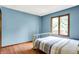 Bedroom featuring hardwood floors and large windows overlooking green backyard space at 50 Charing Cross Rd, Indianapolis, IN 46217