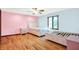 Spacious bedroom featuring hardwood floors, ceiling fan, and a bright window with a backyard view at 50 Charing Cross Rd, Indianapolis, IN 46217