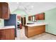 Kitchen featuring light green walls, wood cabinetry, and a vaulted ceiling with fan at 50 Charing Cross Rd, Indianapolis, IN 46217