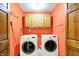 Laundry room featuring two washing machines and upper cabinetry at 50 Charing Cross Rd, Indianapolis, IN 46217
