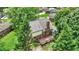 Aerial view showcasing the house's rear exterior, stone chimney, and wood deck surrounded by lush greenery at 50 Charing Cross Rd, Indianapolis, IN 46217
