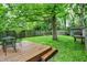 Cozy backyard with wooden deck, metal table and chairs, green lawn, and privacy fence at 514 Dorman St, Indianapolis, IN 46202