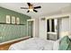 This bedroom features light green walls, hardwood floors, a ceiling fan, and closet storage at 514 Dorman St, Indianapolis, IN 46202