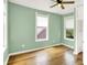 Light green bedroom with hardwood floors and plenty of natural light from the multiple windows at 514 Dorman St, Indianapolis, IN 46202