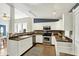 A well-lit kitchen featuring white cabinets, stainless steel appliances, and a stylish backsplash and open access to the dining room at 514 Dorman St, Indianapolis, IN 46202