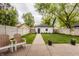 Landscaped backyard with seating area and paved walkway to detached garage with garden at 5254 N Park Ave, Indianapolis, IN 46220