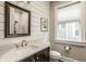 Bright bathroom features a modern vanity with marble countertop and framed mirror, exuding a clean, contemporary style at 5254 N Park Ave, Indianapolis, IN 46220