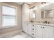 Modern bathroom boasting white cabinets, dual sinks, and a large window that fills the space with natural light at 5254 N Park Ave, Indianapolis, IN 46220