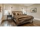 Cozy bedroom features a plush bed with a fur throw, complemented by hardwood floors and natural light from two windows at 5254 N Park Ave, Indianapolis, IN 46220