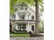 Charming two-story home featuring black framed windows and a welcoming front porch with seating at 5254 N Park Ave, Indianapolis, IN 46220
