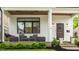 Inviting front porch with comfortable seating, elegant planters, and a beautifully stained front door at 5254 N Park Ave, Indianapolis, IN 46220