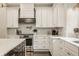 Kitchen featuring stainless steel appliances, white cabinets, chevron backsplash, and a dark stained kitchen island at 5254 N Park Ave, Indianapolis, IN 46220