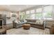 Open concept living room with hardwood floors, large sectional, and views to butler's pantry and outside at 5254 N Park Ave, Indianapolis, IN 46220