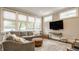 Living room featuring a large gray sectional, decorative ottoman, large windows, and modern decor at 5254 N Park Ave, Indianapolis, IN 46220
