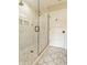 Elegant walk-in shower with marble tiling, glass door, and decorative tile flooring offering a spa-like experience at 5254 N Park Ave, Indianapolis, IN 46220