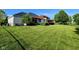 Expansive backyard with green grass, mature trees, a pergola, and a view of the home's exterior at 5347 Sampson Dr, Indianapolis, IN 46237