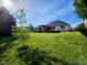 Beautifully landscaped backyard with a well-maintained lawn, a pergola, mature trees, and privacy fencing at 5347 Sampson Dr, Indianapolis, IN 46237