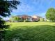 Large backyard with a well-manicured lawn, mature trees, and a pergola-covered patio for outdoor entertaining at 5347 Sampson Dr, Indianapolis, IN 46237