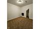 A cozy, carpeted bedroom space with neutral walls and a minimalist window offers an adaptable space at 5347 Sampson Dr, Indianapolis, IN 46237