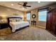 Spacious bedroom with comfortable queen bed, natural light, neutral paint and carpeting, and a decorative ceiling fan at 5347 Sampson Dr, Indianapolis, IN 46237