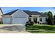 A well-kept white brick home features a two car garage, well manicured landscaping, and a large driveway at 5347 Sampson Dr, Indianapolis, IN 46237