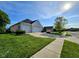 This white brick home has an attached two car garage and a well manicured lawn and landscaping at 5347 Sampson Dr, Indianapolis, IN 46237
