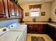 Well-lit laundry room featuring ample counter space, custom cabinetry, and a window at 5347 Sampson Dr, Indianapolis, IN 46237