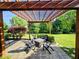Beautiful patio with a wooden pergola, nice furniture, and an outdoor fire pit, surrounded by a well-manicured lawn at 5347 Sampson Dr, Indianapolis, IN 46237