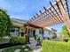 Outdoor living space featuring a pergola-covered patio, lush landscaping, and views of the beautifully maintained backyard at 5347 Sampson Dr, Indianapolis, IN 46237