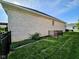 Side of the white brick house featuring a well-manicured lawn and a fenced enclosure at 5347 Sampson Dr, Indianapolis, IN 46237