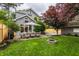 Spacious backyard with patio dining set, fire pit, lush lawn, wooden fence, and home exterior at 5430 N Washington Blvd, Indianapolis, IN 46220